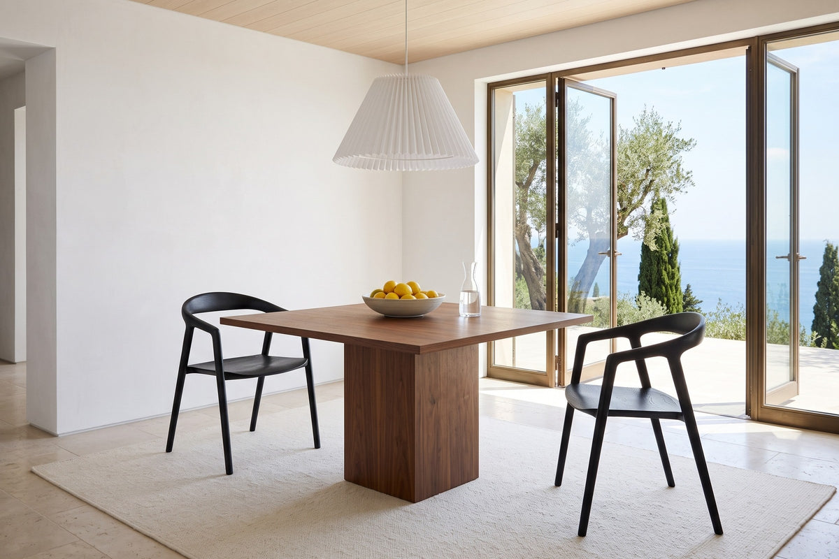 Two Pollica dining chairs in Black at a square walnut pedestal table in a Portofino hillside villa
