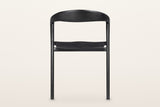 Pollica dining chair in Black from behind on a warm white studio backdrop