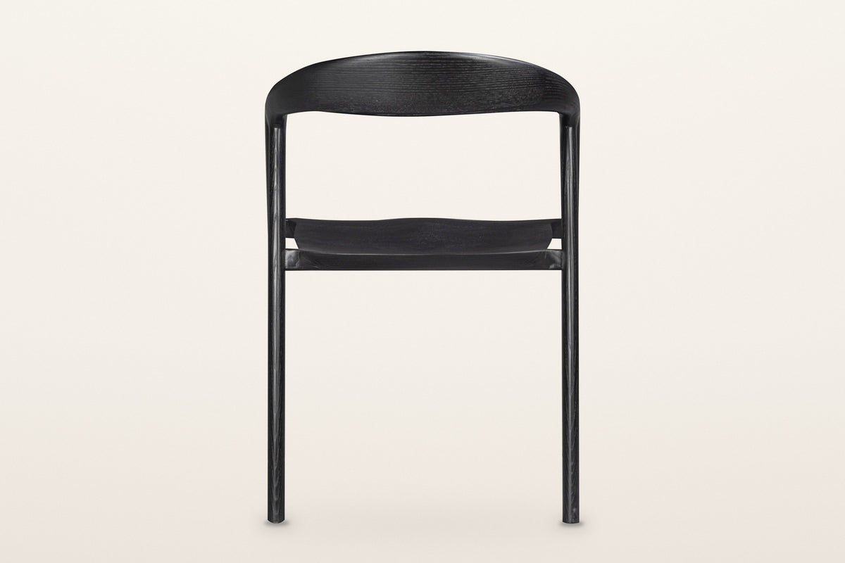 Pollica dining chair in Black from behind on a warm white studio backdrop