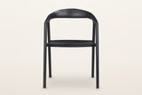 Pollica dining chair in Black, straight front view on a warm white studio backdrop