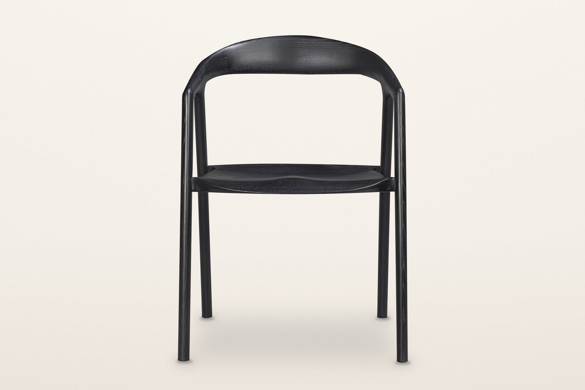 Pollica dining chair in Black, straight front view on a warm white studio backdrop