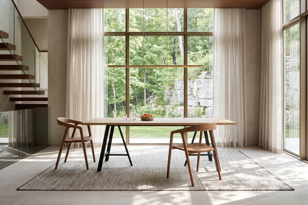 Two Pollica dining chairs in Caramel at the ends of a long white-oak table in a Mono Cliffs house