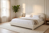 Pollutri bed in cream boucle made up with white linen, in a bright bedroom with a fiddle-leaf fig and pale oak nightstands