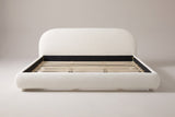 Pollutri upholstered bed in cream white boucle, straight front view on a studio backdrop