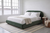 Pollutri bed in dark green velvet in a white board-walled bedroom looking onto the harbour