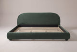 Pollutri upholstered bed in dark green velvet, straight front view on a studio backdrop
