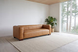 Pontremoli leather sofa in Latte in a cedar-ceilinged Kitsilano, Vancouver living room, tall firs through the window