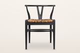 Poppi Y-back dining chair in Black, front view on a warm white studio backdrop: a black teak frame with a natural abaca seat