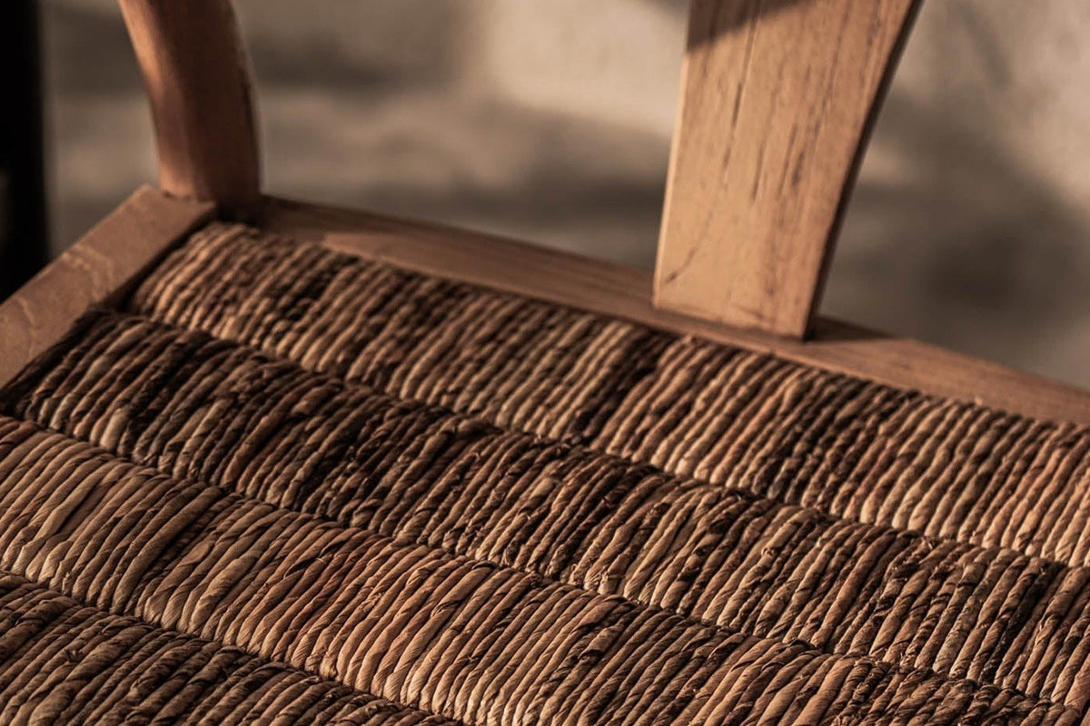 Close-up of the Poppi seat in Brown: plump rolls of woven abaca set side to side in a frame of flat reclaimed teak boards
