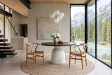 Two Poppi dining chairs in Brown at a round smoked-oak table on a white pedestal in a mountain house in Field