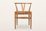 Poppi Y-back dining chair in Brown, front view on a warm white studio backdrop: a curved top rail, a Y-shaped back splat