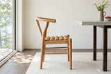 A Poppi dining chair in Brown in side profile beside a pale limestone table in a Westport house on Big Rideau Lake