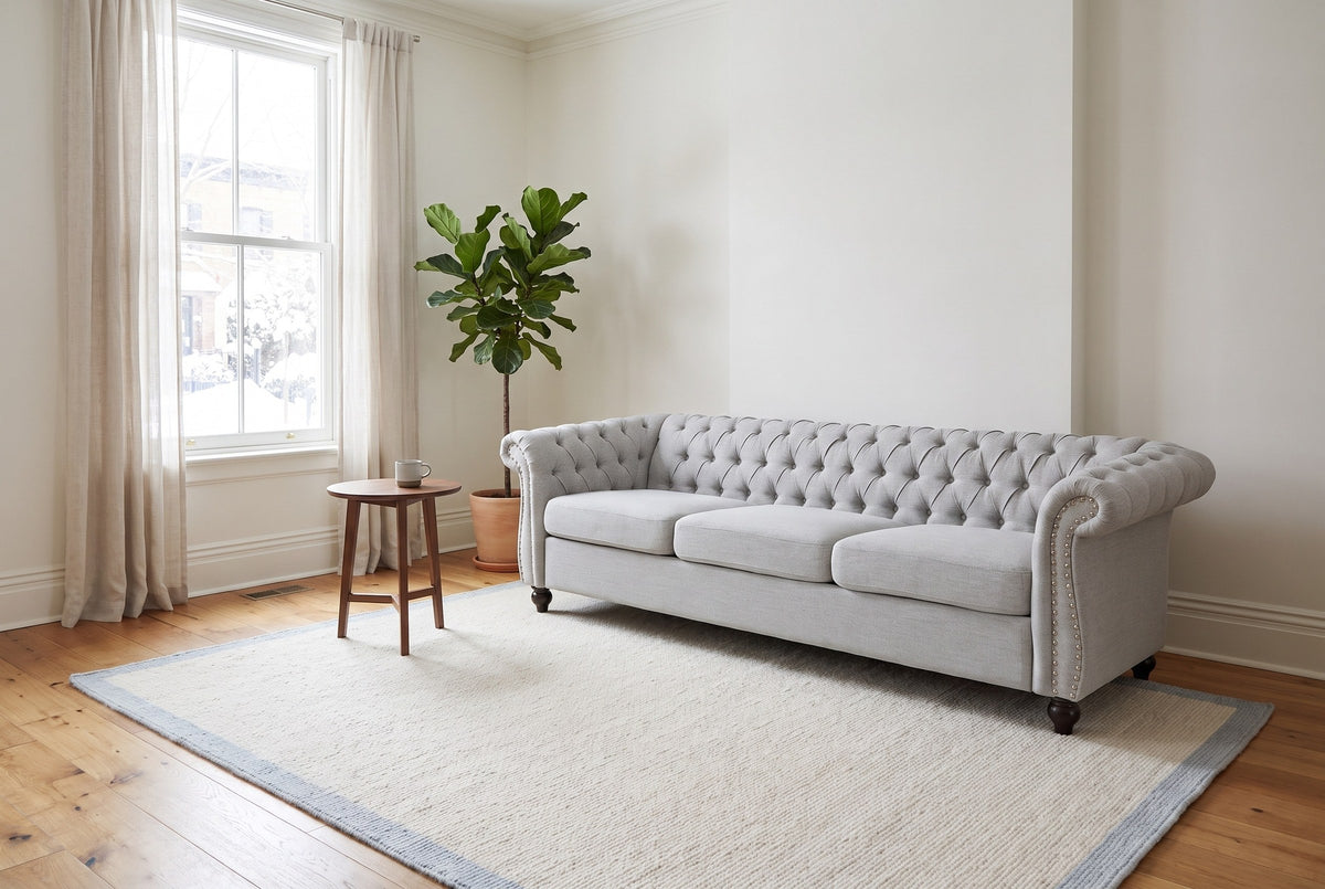 Portovenere sofa in the bright front room of an Ottawa townhouse on a snowy morning, a fig tree and a walnut side table beside it