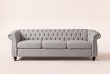 Portovenere sofa in grey, straight front view: a button-tufted back, three seat cushions, scrolled arms with silver nailheads