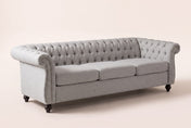 Portovenere Chesterfield sofa in grey fabric on four turned espresso feet, three-quarter view on a warm cream studio backdrop