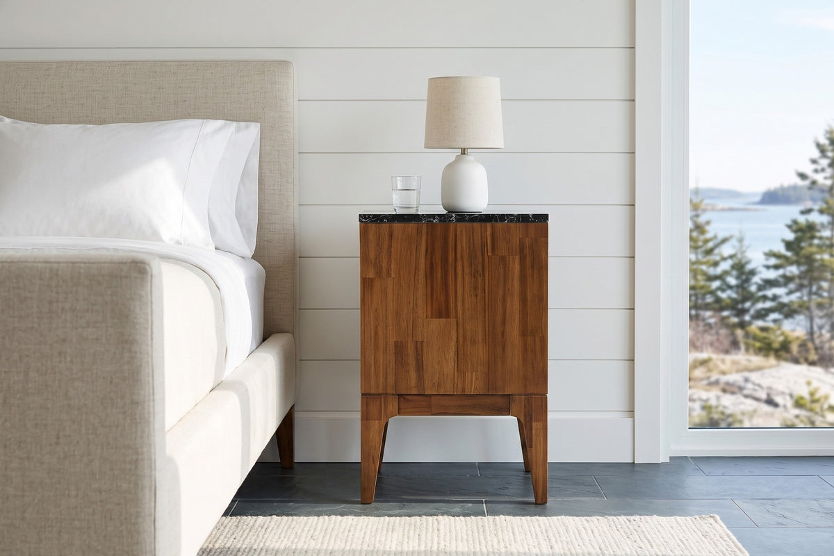End view of the Postignano nightstand, its acacia side and black marble edge