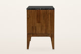 Side view of the Postignano nightstand in Walnut on a warm white studio backdrop: a side of short acacia blocks under the bla