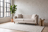 Prato sofa against a white brick wall in a Montreal loft, steel windows and a fig tree beside it