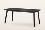 Prescott round-leg extension dining table in Antique Black, closed to 70 in, three-quarter view on a warm white studio backdrop