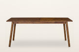 Prescott extension dining table in Brown seen straight on along the long side: the plain apron and four round tapered legs, no stretchers