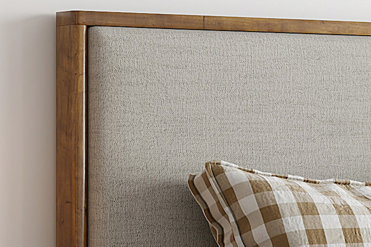 Quinn bed close-up of the walnut-finished wood frame around the oat headboard