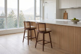 Two Rasiglia counter stools at a fluted oak island with a stone top in a bright Vancouver condo kitchen