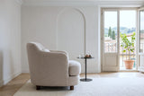 Ripatransone accent chair in Beige in side profile in a Florence Oltrarno apartment, with chalk-white plaster