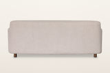Back of the Ripatransone sofa in Beige on a warm white studio backdrop: a plain upholstered back with a soft curved top