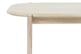 Close-up of a Rivello corner in Light Oak: a round leg rising through a notch in the edge