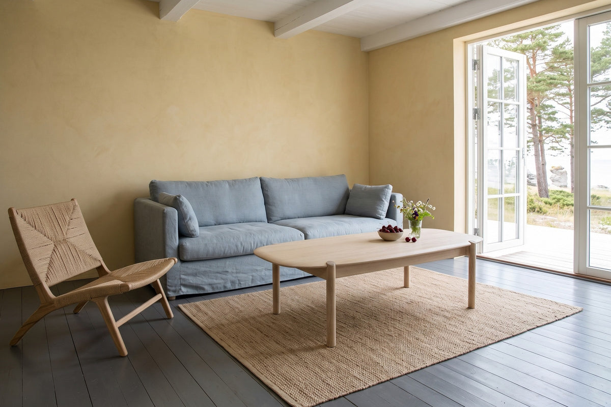 Rivello coffee table in Light Oak seen from above at the corner in a Gotland limestone house, with ochre limewash