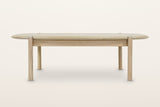 Rivello coffee table in Light Oak from the front on a warm white studio backdrop: legs set in from the rounded ends