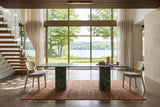 Two Rivello dining chairs at the ends of a dark green marble table in a North Hatley house