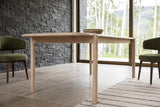 A Rivello corner in Light Oak at seat height in the Smithers house: a round leg in its notch and the rail under the top