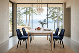 End view of the Rivello dining table in Light Oak in a Hornby Island bluff house, with greige plaster, a glass globe cluster