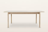 Rivello dining table in Light Oak, front view on a warm white studio backdrop