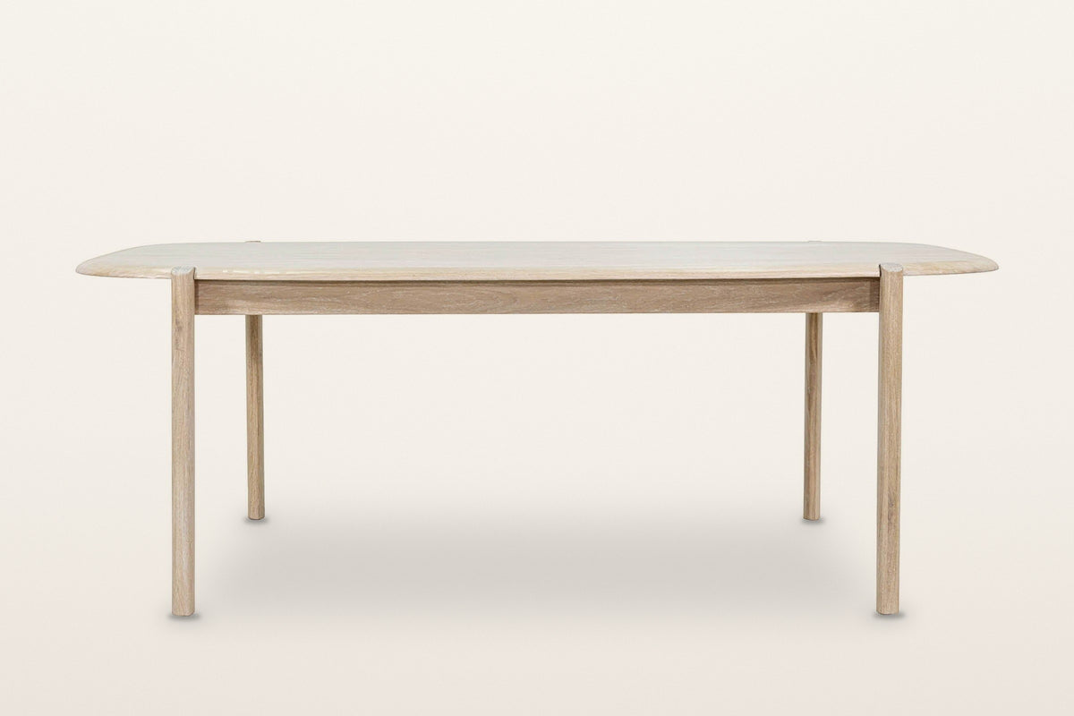 Rivello dining table in Light Oak, front view on a warm white studio backdrop