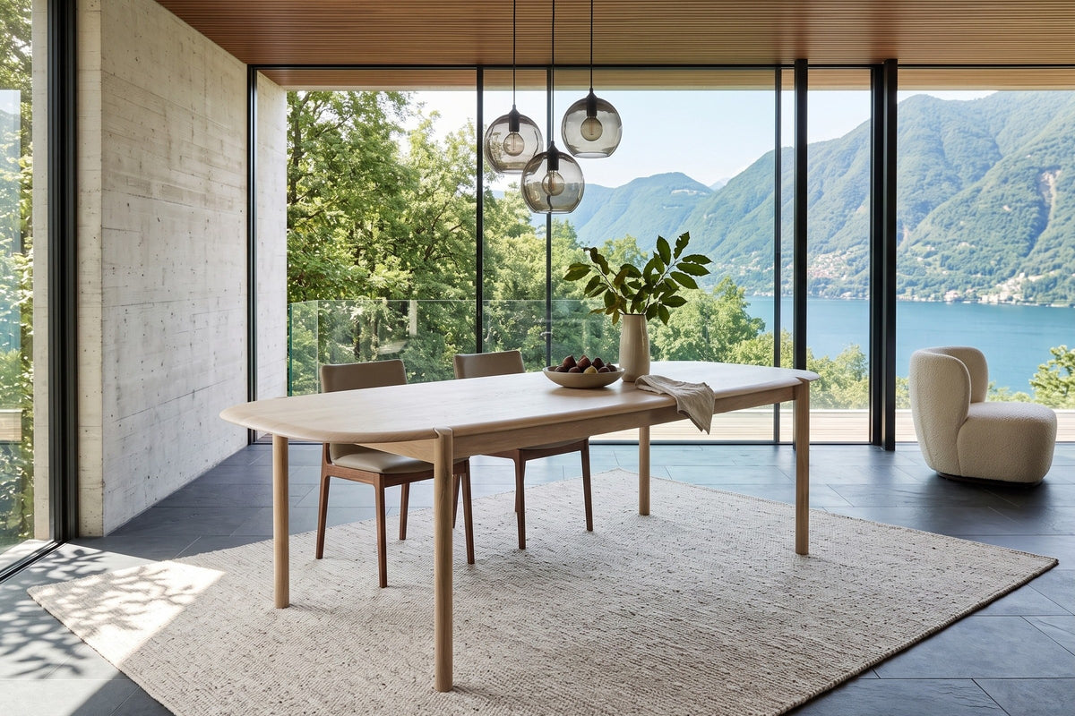 Rivello dining table in Light Oak in a Ticino stone house above Lake Lugano, with a board-formed concrete wall