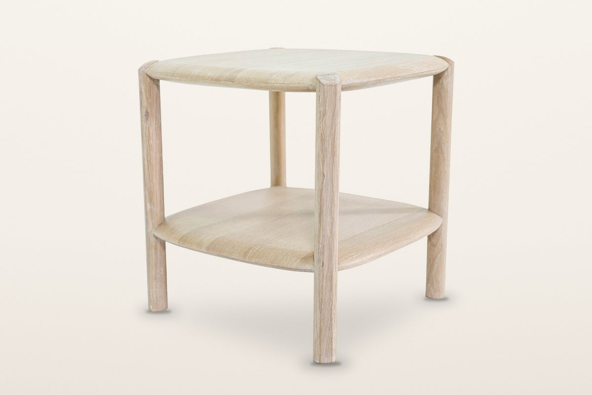 Rivello side table in Light Oak at eye level, three-quarter view on a warm white studio backdrop: four round legs outside