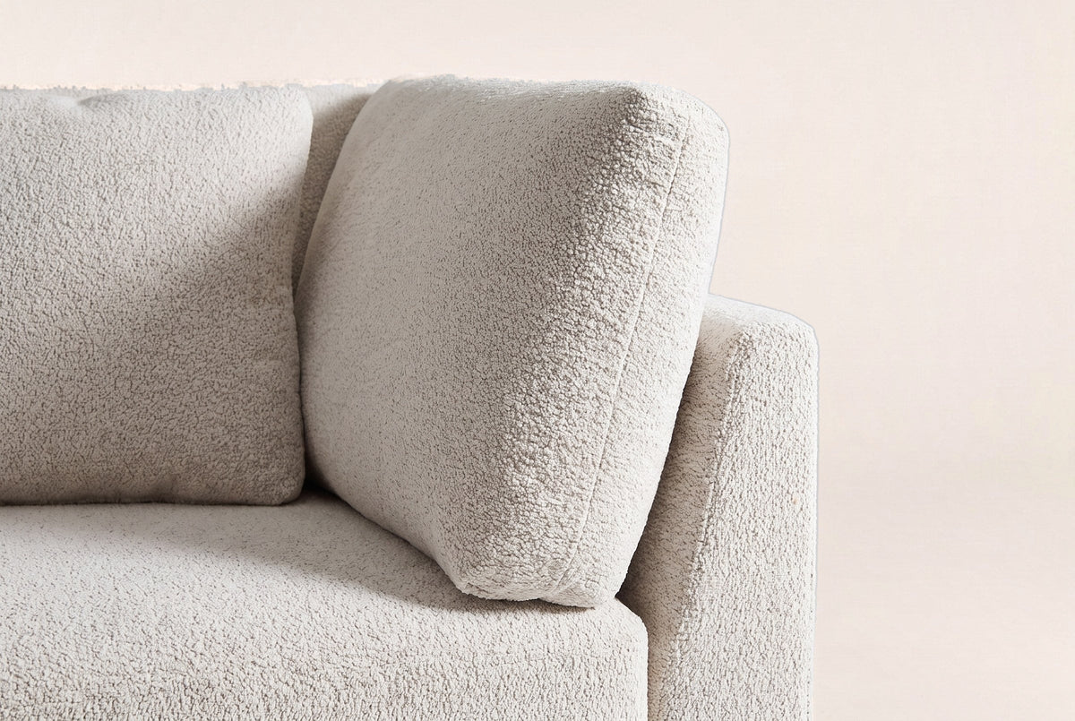 Close-up of the beige chenille arm pillow, the seat cushion and the square top of the flared arm