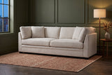 Rovigo sofa against olive-green panelled walls in an Ottawa townhouse at dusk, a floor lamp lit beside it