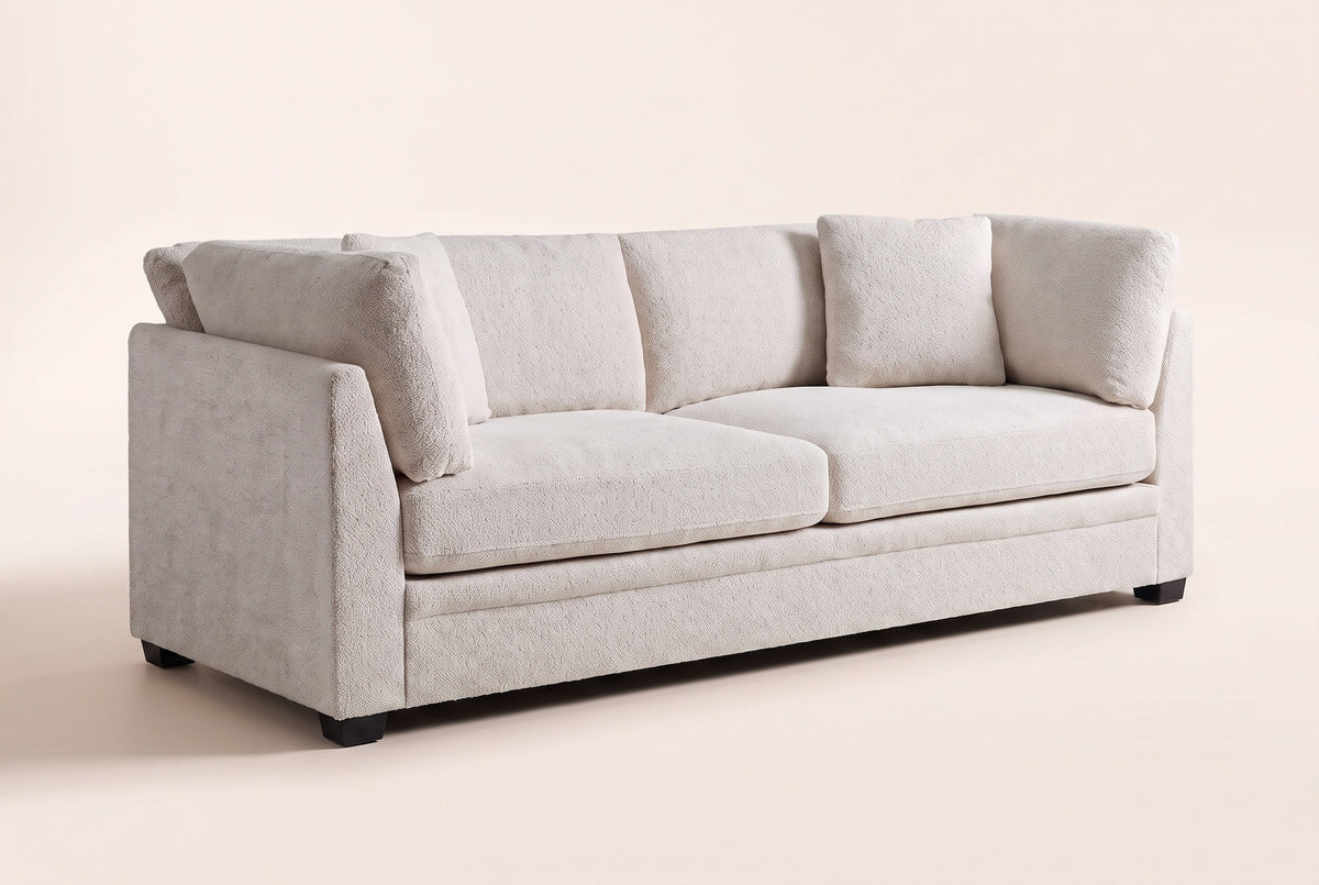 Rovigo flared-arm sofa in beige chenille, three-quarter view on a warm off-white studio backdrop