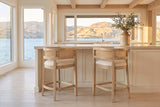 Two Sabaudia counter stools in Natural Ash at a warm-white island with a limestone counter in a Kelowna lake house