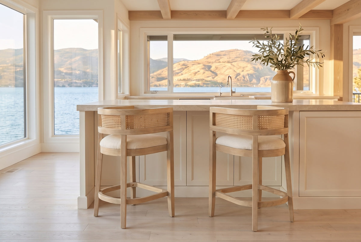 Two Sabaudia counter stools in Natural Ash at a warm-white island with a limestone counter in a Kelowna lake house