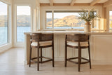 Two Sabaudia counter stools in Walnut at a warm-white island with a limestone counter in a Kelowna lake house