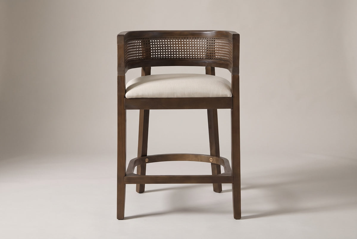 Sabaudia counter stool in Walnut, straight front view showing the barrel back, the cane-look band, the footrest and four legs