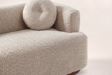 Close-up of the Almond boucle bench seat, a round button pillow and the block arm