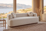 Sabbioneta sofa in Almond boucle in a Kelowna lake house with a jute rug, a rush stool and Okanagan Lake through the windows