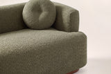 Close-up of the olive green boucle bench seat, a round button pillow and the block arm