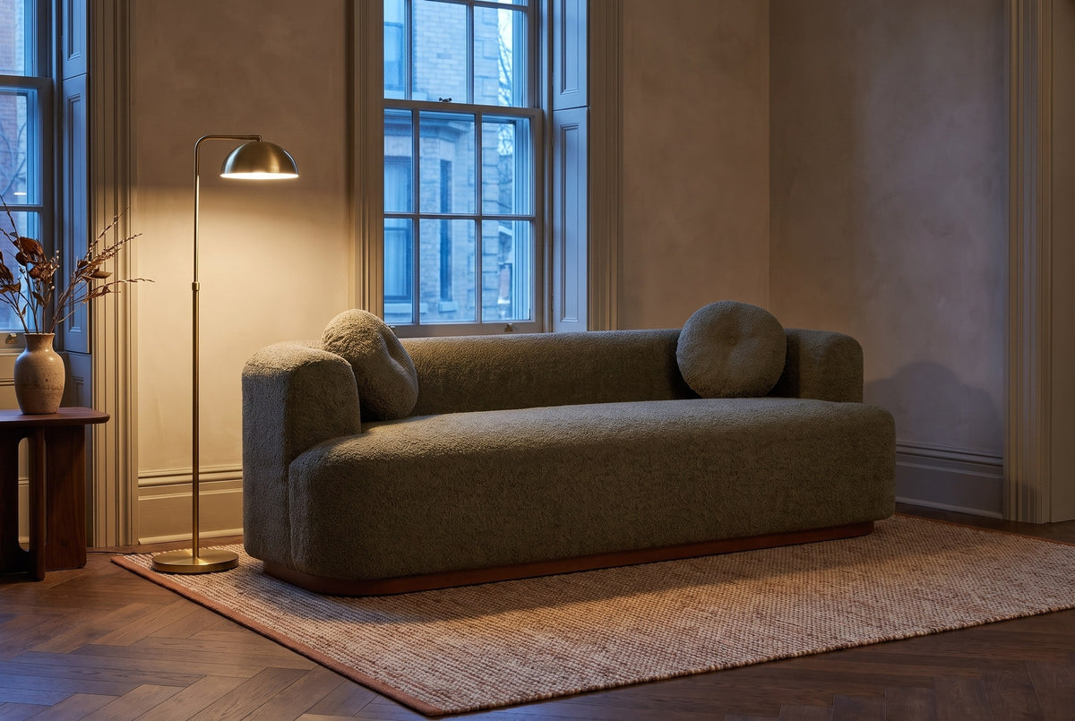 Sabbioneta sofa in an Ottawa townhouse sitting room at dusk, a brass floor lamp lit beside it