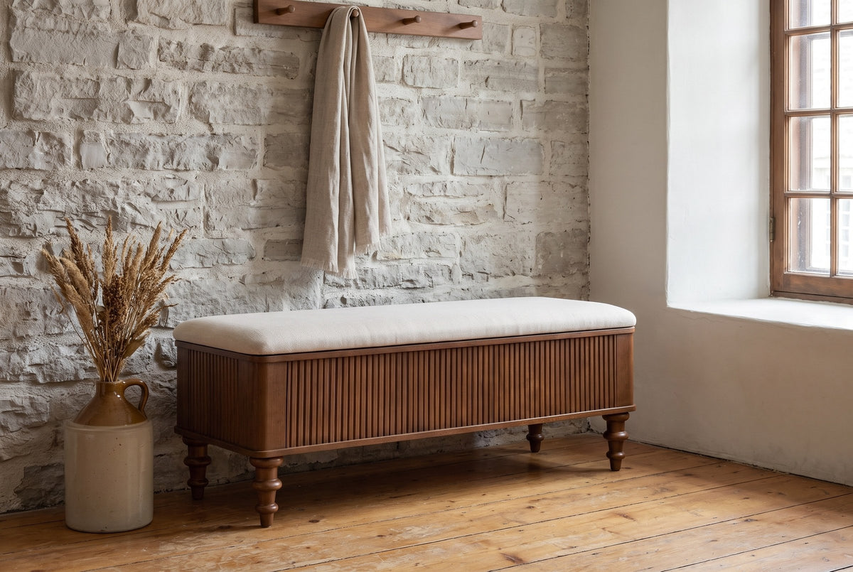 Salerno storage bench against a limestone wall in a Quebec City entry, a linen scarf on the peg rail above and dried grasses beside it
